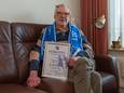 Martin Bos toont trots de oorkonde die hij ontving omdat hij 75 jaar lid is van AGOVV.