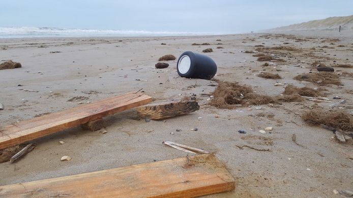 Een van de aangespoelde urnen op het strand.