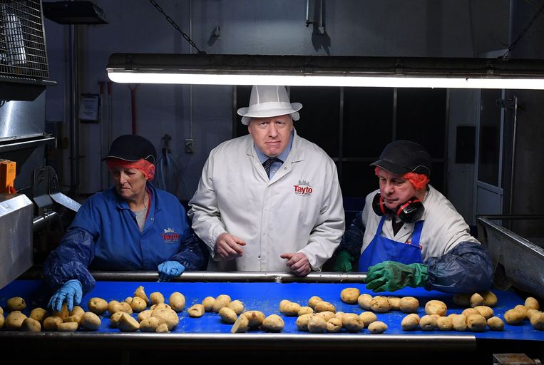 In aanloop naar de verkiezingen op 12 december is de Britse premier Boris Johnson op bezoek bij een chipsfabriek in het Noord-Ierse graafschap Armagh. Hij helpt de kwaliteitscontroleurs de geschikte van de inferieure piepers te scheiden. Beeld AFP