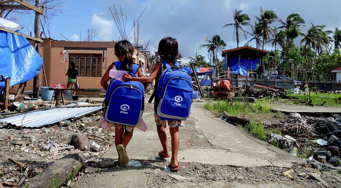 Filipijnse kinderen met een rugzak van Plan Internationaal na de orkaan Haiyan in 2013.