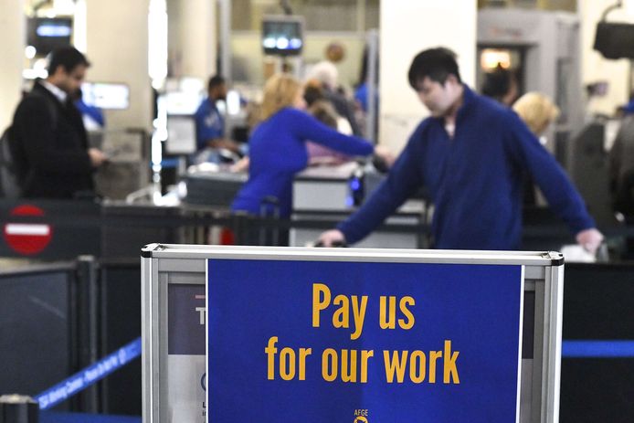 ‘Betaal ons voor ons werk’ staat op een bord in Philadelphia Airport.