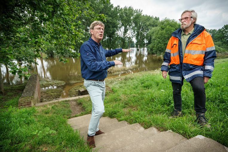 Bestuurder Jos Teeuwen (hoogwater bescherming en kering, links) en Mart Peters (vrijwillige dijkwacht, oranje jas) vertellen langs de Maas wat er sinds 1995 allemaal verbeterd is. 
 Beeld Maikel Samuels