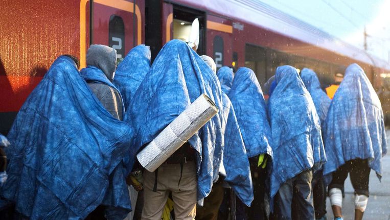 Vluchtelingen stappen in de trein richting München. Beeld Reuters