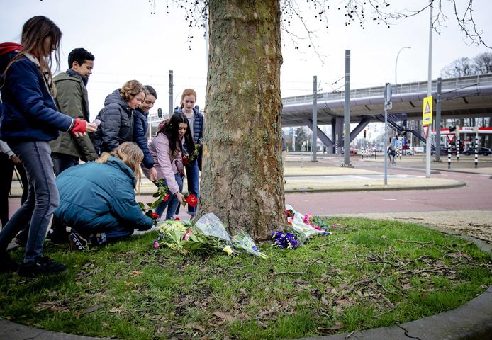 Kinderen leggen bloemen neer vlak bij de tramhalte waar Gökmen Tanis (37) het vuur opende.