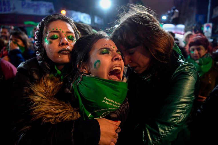 Voorstanders van de legalisering van abortus, getooid met groene sjaals, troosten elkaar woensdag in Buenos Aires nadat de Argentijnse Senaat de wet heeft verworpen. Beeld AFP