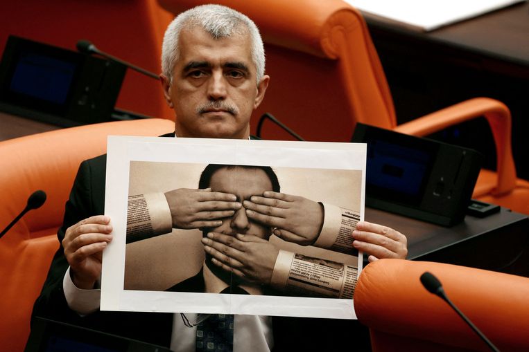 Ömer Faruk Gergerlioglu, parlementslid voor de oppositiepartij HDP en bekend als activist en mensenrechtenverdediger, laat bij de parlementsstemming over de nieuwe wet uit protest deze foto zien. Beeld AFP