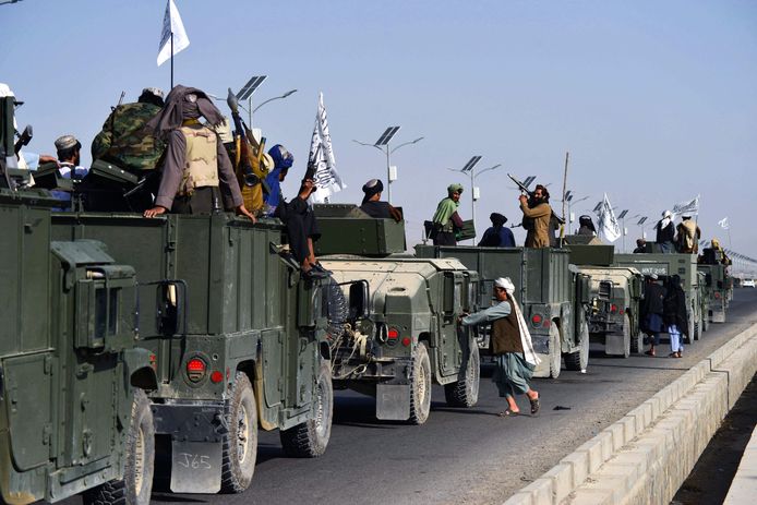 Talibanstrijders op door de VS achtergelaten Humvees.