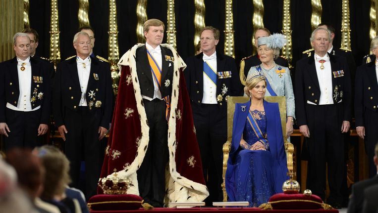 Koning Willem-Alexander voorafgaand aan het afleggen van de eed tijdens zijn inhuldiging in De Nieuwe Kerk, 30 april 2013. Naast hem - niet staand, maar zittend - koningin Maxima. Op de achtergrond leden van de hofhouding. Beeld anp