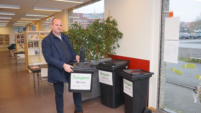 Voorzitter Jens De Wael bij de democontainers in de bibliotheek. Alle inwoners moeten een keuze maken uit drie types capaciteit.