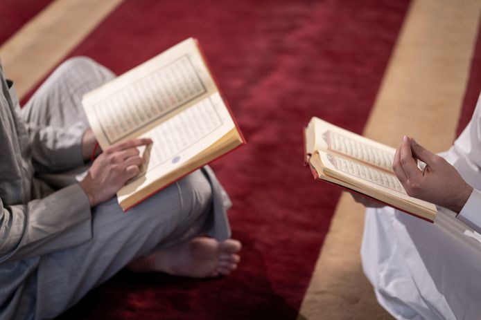 Muslim praying inside mosque reading Koran