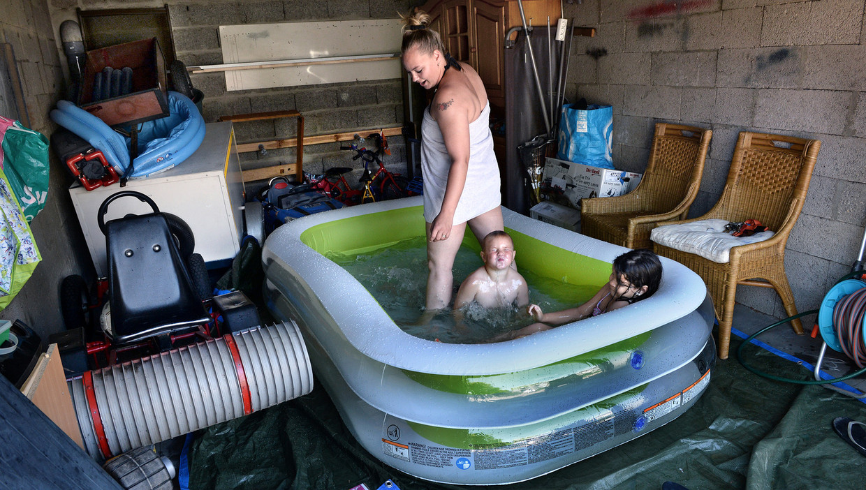 Een familie in Nijmegen heeft het kinderbadje in de garage gezet omdat het in de tuin te heet is. Beeld Marcel van den Bergh / de Volkskrant