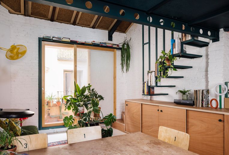 Achter het schuifraam paalt een klein terras. Het rechter paneel met geperforeerd metaal dient als zonnewering en geeft extra privacy. De houten kast rechts doet ook dienst als onderdeel van de trap. De gele ventilator is een ontwerp van de architecte. Beeld ROCIO ROMERO RIVAS