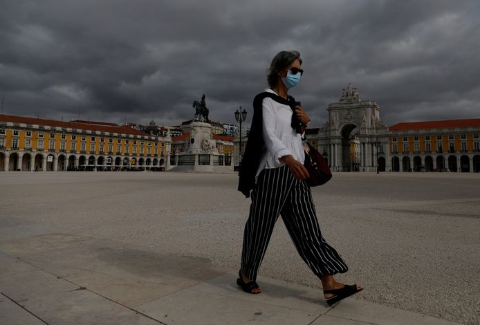Een vrouw met mondmasker op een verlaten plein in de Portugese hoofdstad Lissabon.