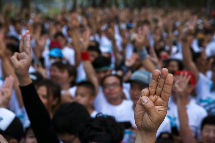 Joggers steken drie vingers op tijdens de protestjog ‘Run Against Dictatorship’ in een park in Bangkok.
