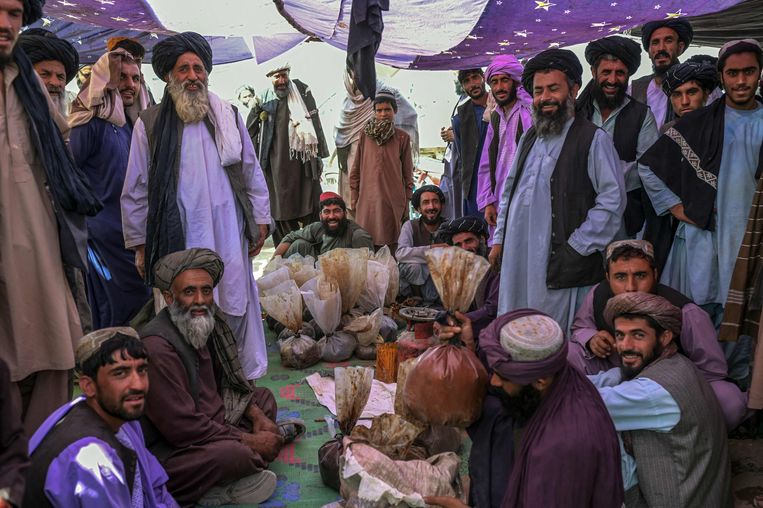 Op een markt in een buitenwijk van Kandahar wordt onderhandeld over de verkoop van heroïne en hasj. De drugs zijn in zakken verpakt, september 2021.  Beeld Bülent Kiliç / AFP
