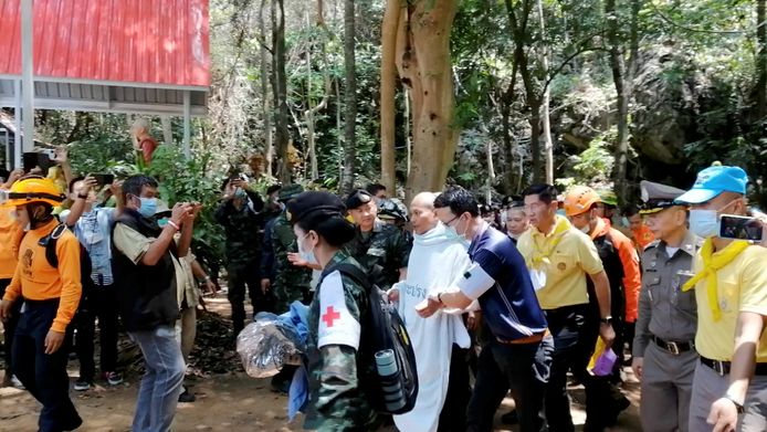 Reddingswerkers lopen samen met de 46-jarige monnik Phra Manas de Tham Phra Sai Ngam-grot uit, nadat hij daar vier dagen had vastgezeten door overstromingen.
