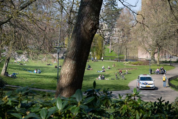 Politie surveilleert zaterdagmiddag in het Kronenburgerpark. Bekeuringen worden niet uitgedeeld. Hoewel het druk is, lijken zonaanbidders zich in tegenstelling tot een dag eerder aan de coronamaatregelen te houden.