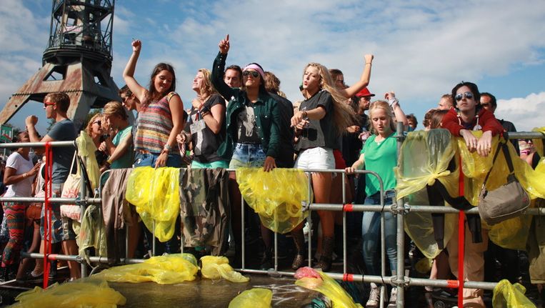 Na een eerste grote bui gingen de poncho's bij het Y-stage weer uit Beeld Foto's: Suzanne Borgdorff en Jacqueline Hamizadeh