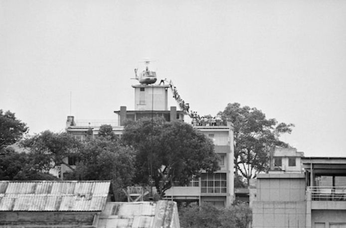 Een medewerker van de CIA helpt de laatste Vietnamese vluchtelingen in een helikopter aan Gia Long Street op 29 april 1975. Een dag later viel Saigon.