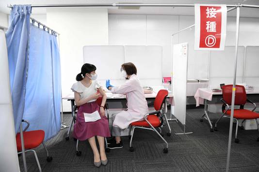 Een stewardess van de Japanse luchtvaartmaatschappij Japan Airlines wordt gevaccineerd met het Moderna-vaccin op de luchthaven Haneda in Tokio.