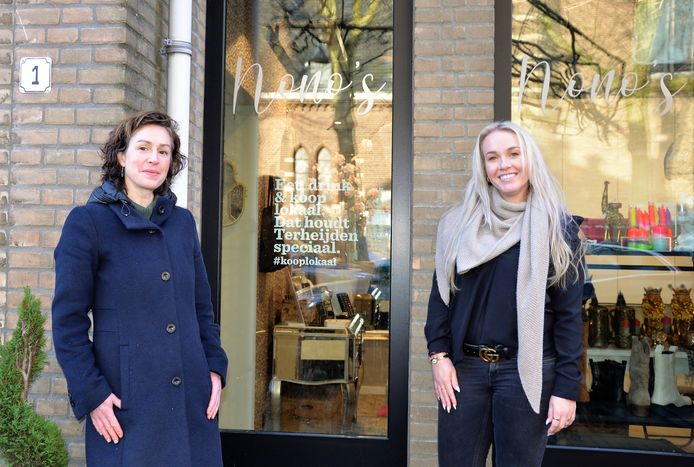 Wethouder Lieke Schuitmaker en ondernemer Jip van Dijk voor haar winkel Nono's Boetiek. Daarop prijkt de eerste raamsticker van de Terheijdense 'koop lokaal'-actie.