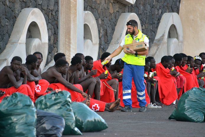 Migranten krijgen eten en drinken nadat ze op zee gered werden. Beeld van 14 oktober in El Hierro, Canarische Eilanden.