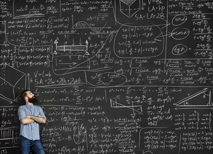 Een man voor een schoolbord vol met wiskundige formules.