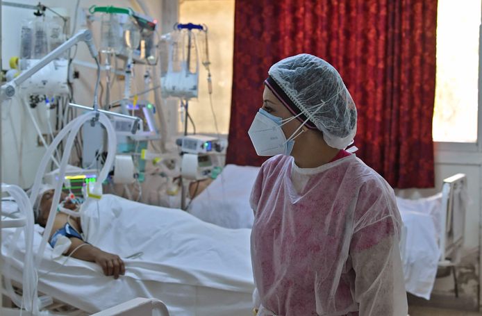 Een verpleegster bij een coronapatiënt in een sporthal die tot ziekenhuis werd omgebouwd in de Tunesische stad Kairouan.