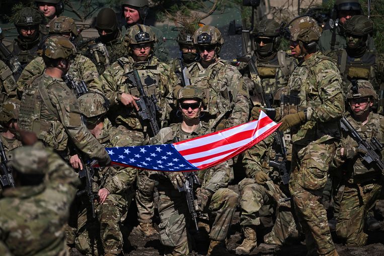 Amerikaanse militairen poseren met de stars-and-stripes, voor de start van een oefening in het Poolse Nowa Deba. Beeld Getty Images