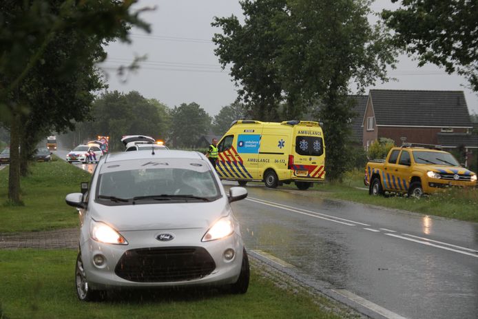 Een ambulance voert de fietser af die even daarvoor is geschept door de grijze auto op de voorgrond.
