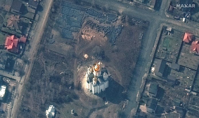 Op dit satellietbeeld dat Maxar Technologies gisteren vrijgaf, is een massagraf te zien (de bruine omgewoelde grond centraal bovenaan in beeld) aan de Church of Saint Andrew and Pyervozvannoho All Saints in Boetsja.