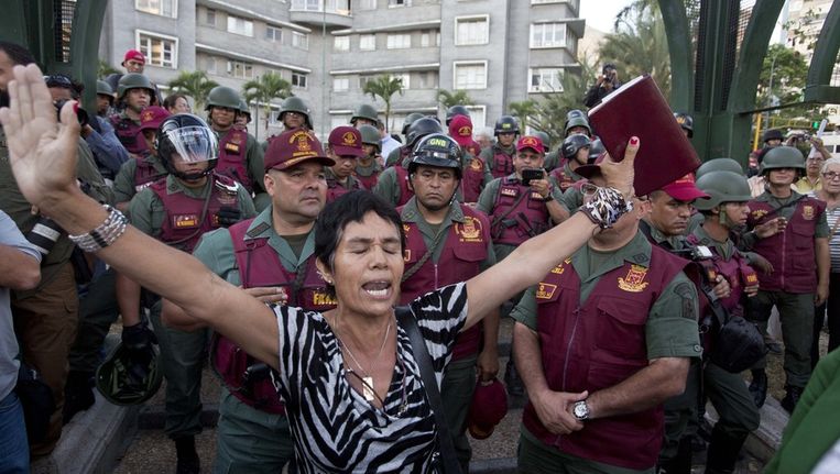 Een vrouw staat voor ordetroepen in Caracas, Venezuela Beeld ap