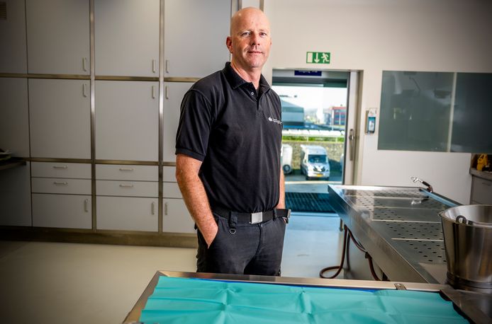 Charles Willemsen in de onderzoekskamer van het NFI waar hij 13 jaar als sectie-assistent werkte. Nu brengt de bus - buiten op de parkeerplaats - hem door heel het land voor forensisch onderzoek.