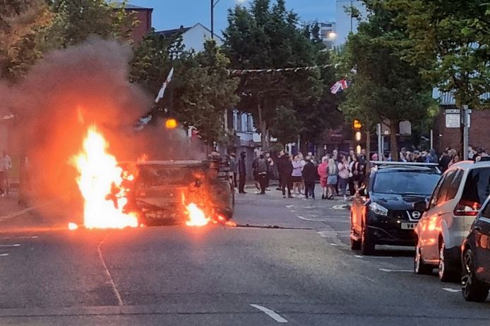 Een voertuig wordt in brand gestoken in Belfast, Noord-Ierland, na een anti-islamitisch protest buiten het stadhuis van Belfast op zaterdag 3 augustus 2024. (David Young/PA via AP)