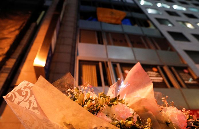 Voor het deels uitgebrande gebouw in Osaka liggen bloemen ter nagedachtenis van de slachtoffers.