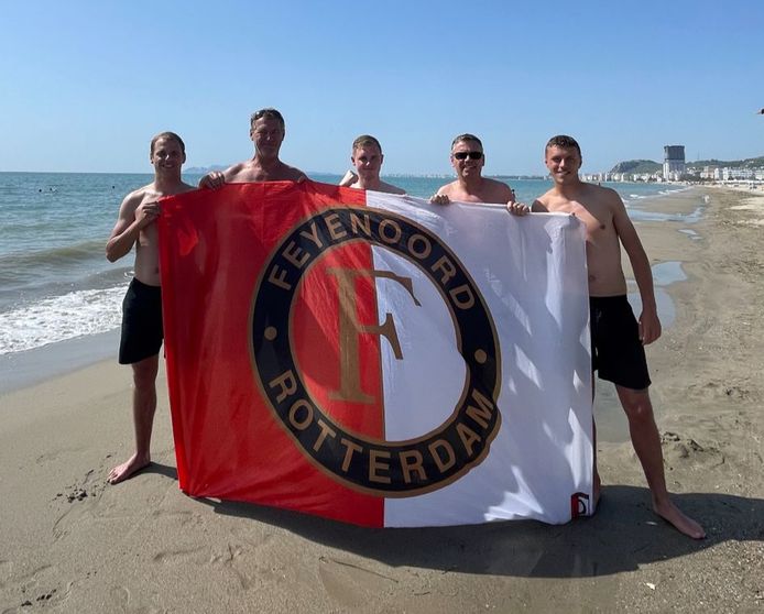 Sven Heijboer (rechts) met de Feyenoord-vlag  op het strand in Albanië.