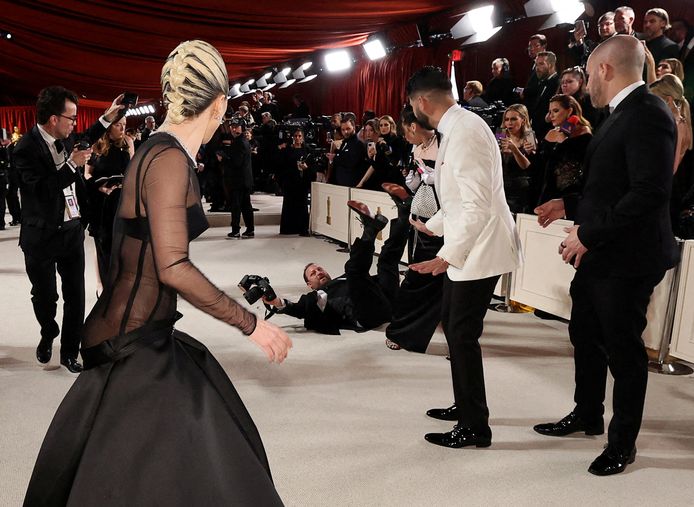Lady Gaga réagit après la chute d'un photographe sur le tapis rouge des Oscars.