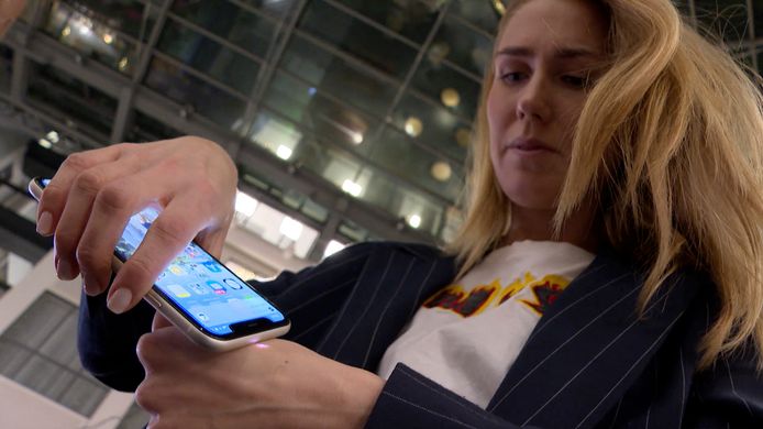 Amanda Back, responsable marketing à l'Epicenter Stockholm, scanne avec un smartphone une micro-puce développée par la société DSruptive Subdermals et implantée dans sa main pour révéler son pass sanitaire.