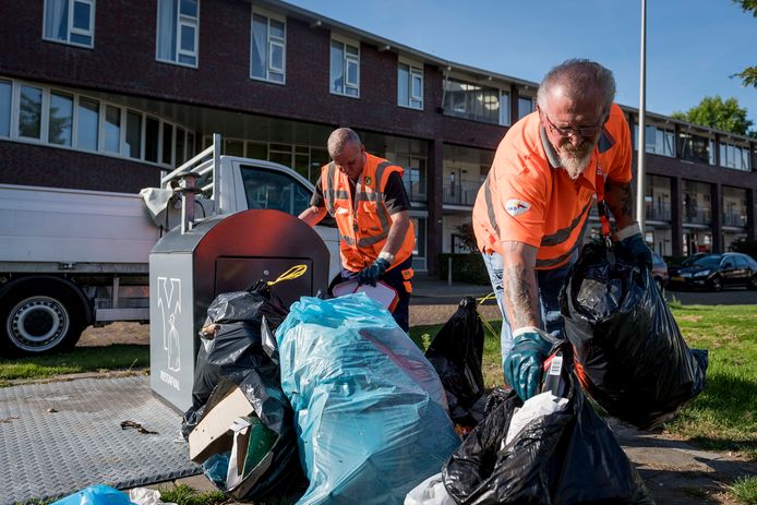 Medewerkers van Gildebor halen het afval weg dat Hengeloërs naast de container hebben geplaatst.