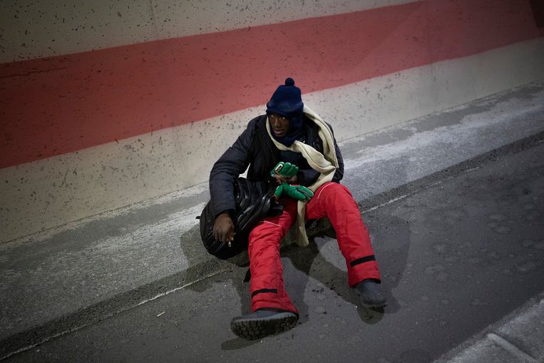 Een migrant onderweg naar Frankrijk stopt om uit te rusten terwijl hij  naar de grens loopt, 11 december 2021.  Beeld AP