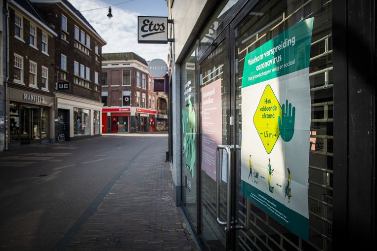 Een aanplakbiljet dat aangeeft dat klanten 1,5 meter afstand moeten bewaren in een winkelstraat in Haarlem.  Beeld ANP