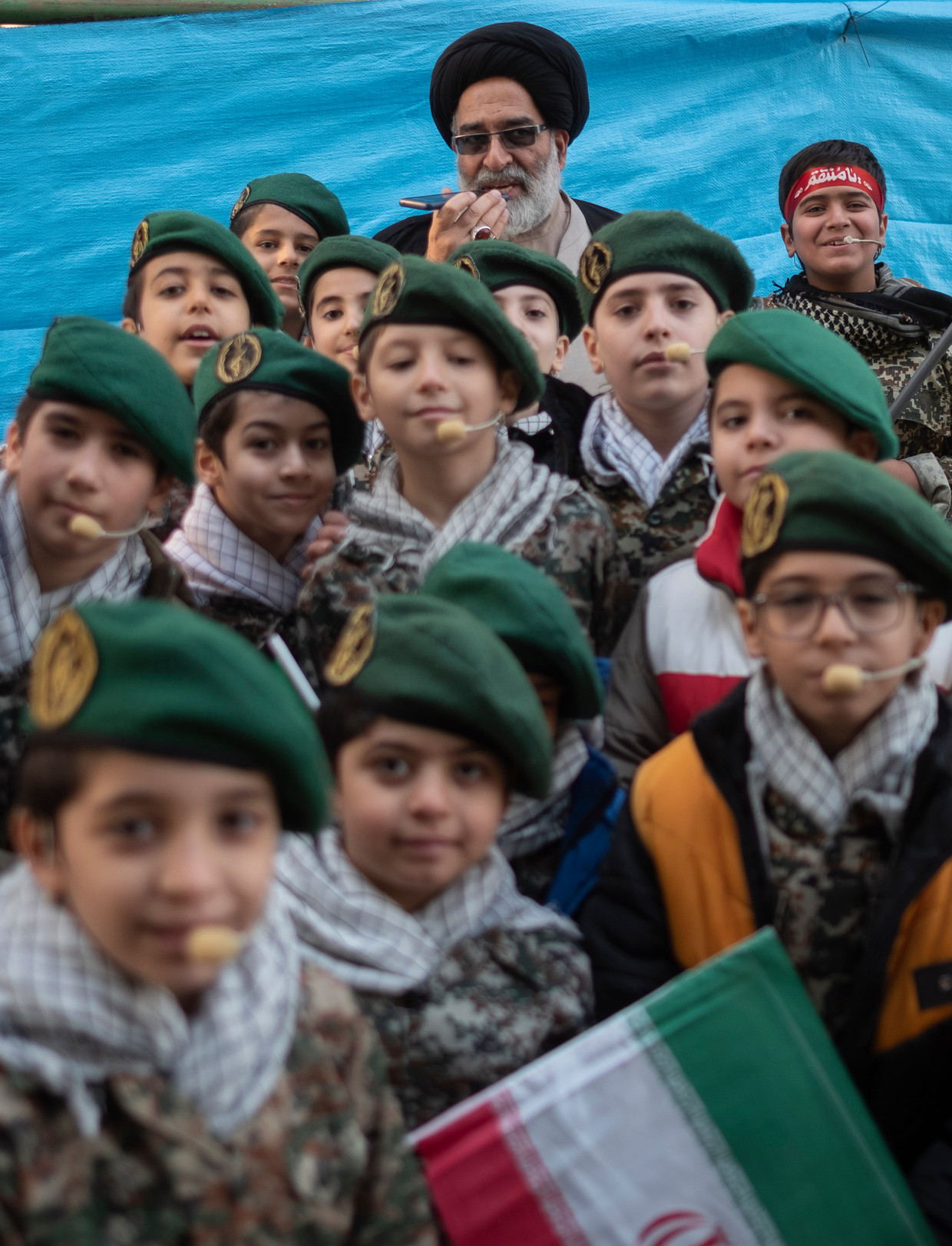 Jonge leden van de Revolutionaire Garde poseren in december in Teheran met een geestelijke voorafgaand aan een pro-regeringsdemonstratie.  Beeld Morteza NikoubazNurPhoto via Getty Images