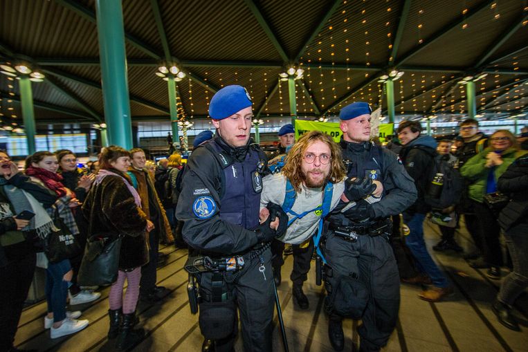Greenpeacedemonstrant wordt opgepakt door de marechaussee op Schiphol. Beeld Jean-Pierre Jans
