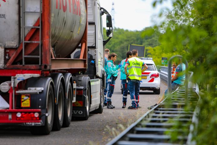 Ambulancepersoneel staat bij de vrachtauto die de voetganger heeft aangereden.
