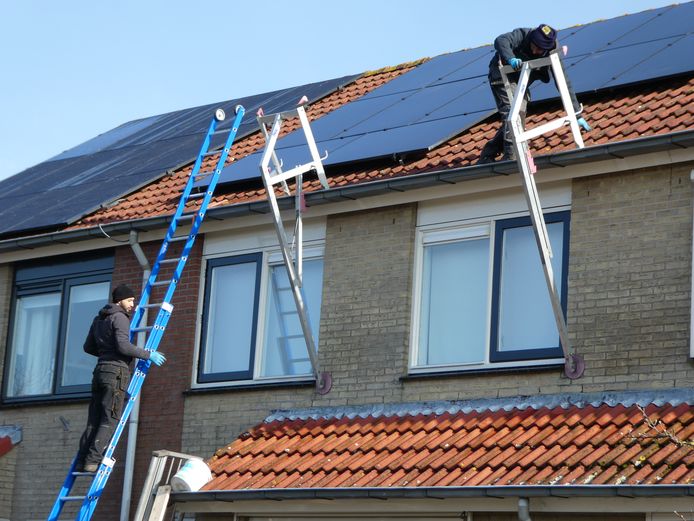 Installateurs leggen zonnepanelen op een woning in Lopik-Dorp.