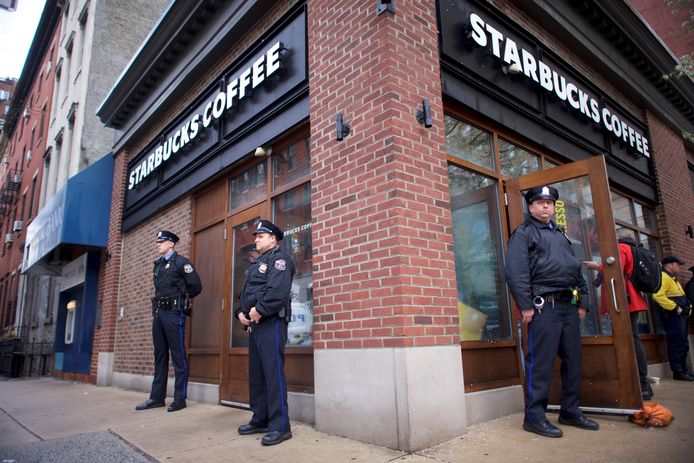 Politieagenten aan het Starbucks-filiaal in Philadelphia waar vorige week donderdag twee zwarte mannen werden opgepakt zonder enige aanleiding.