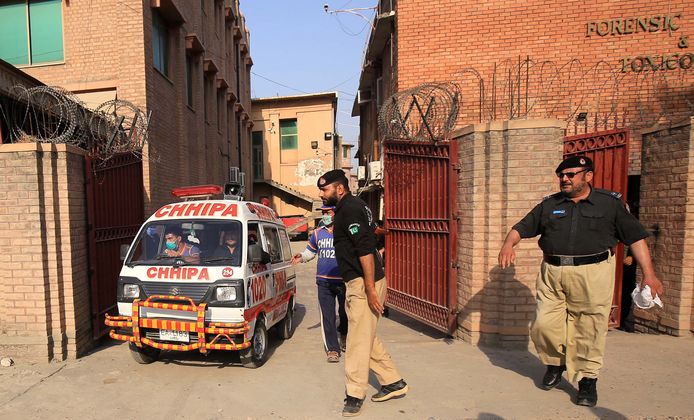 Een ambulance transporteert het lichaam van Tahir Ahmad Naseem, de man die terechtstond voor blasfemie maar werd doodgeschoten tijdens zijn hoorzitting.
