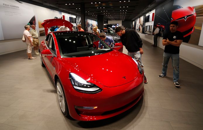 Potentiële kopers bewonderen een Tesla Model 3 in een showroom in Denver. Uit Amerikaans onderzoek blijkt dat de veiligheidssystemen van deze auto regelmatig falen.