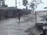 Water stroomt door verwoeste straten Bangladesh na cycloon