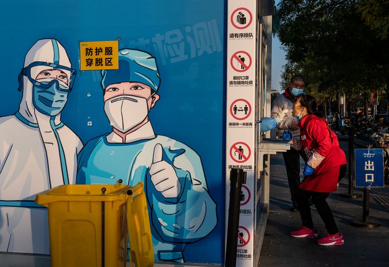 Een vrouw ondergaat een test bij een kiosk op straat in Peking. Beeld Getty Images